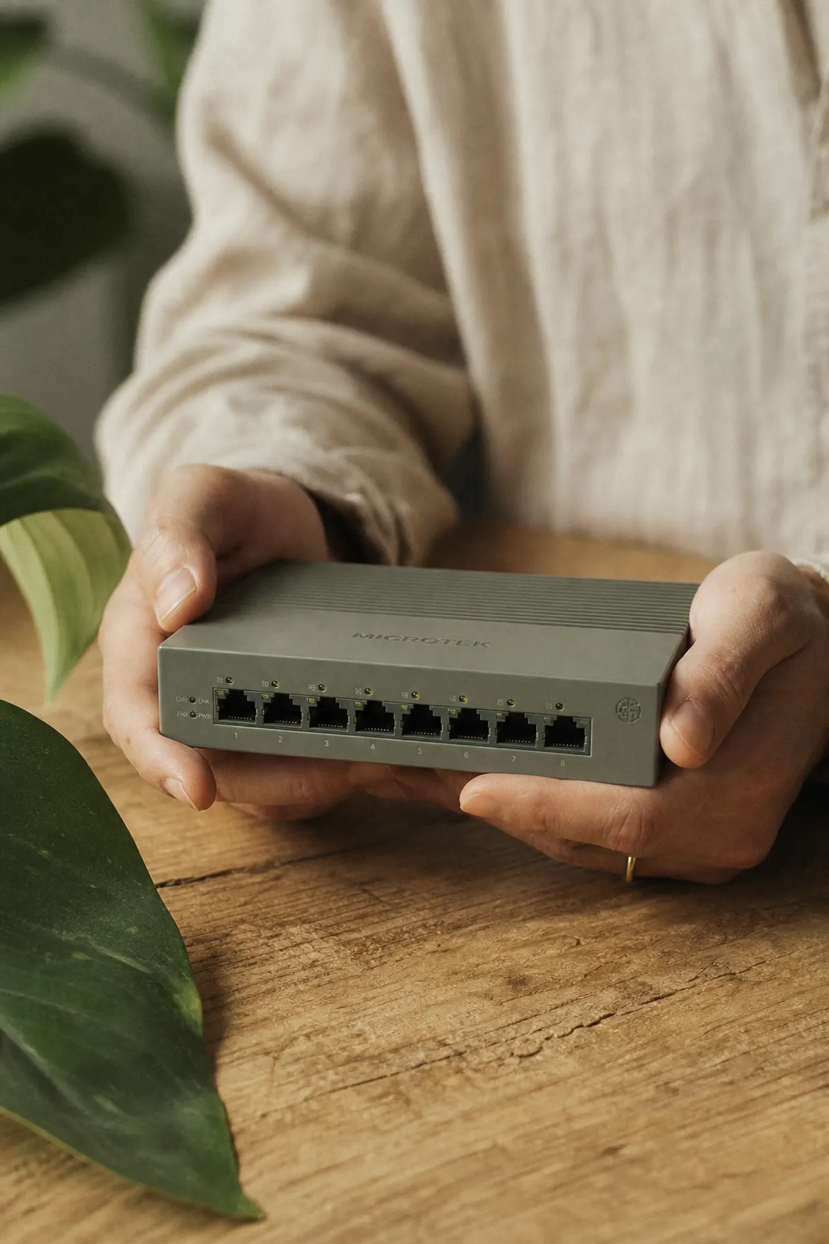 Hands inspecting a small piece of network hardware